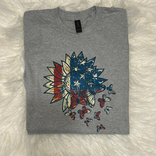 Gray t-shirt with a colorful graphic design on a white fluffy surface