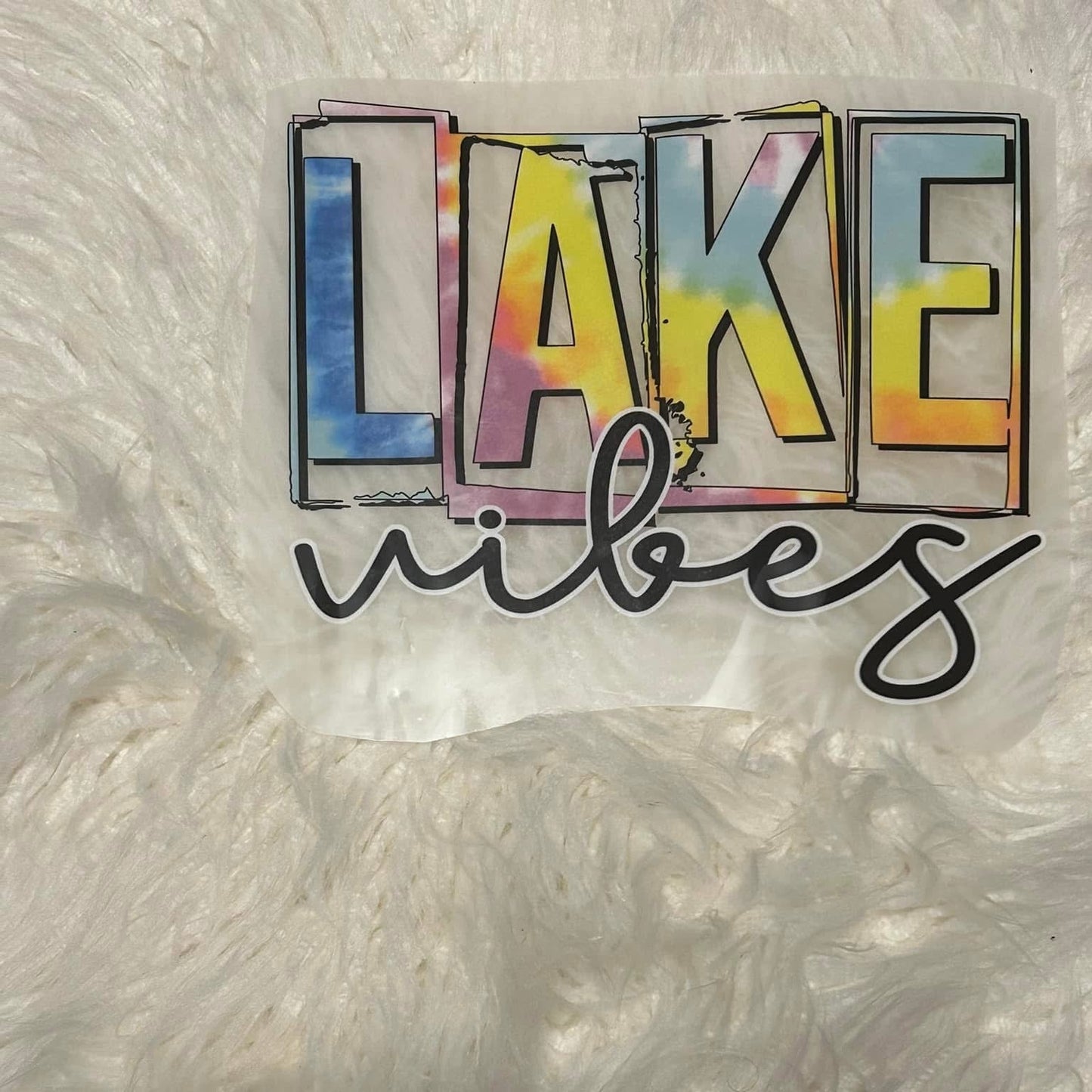 Colorful 'Lake vibes' text on a textured white background