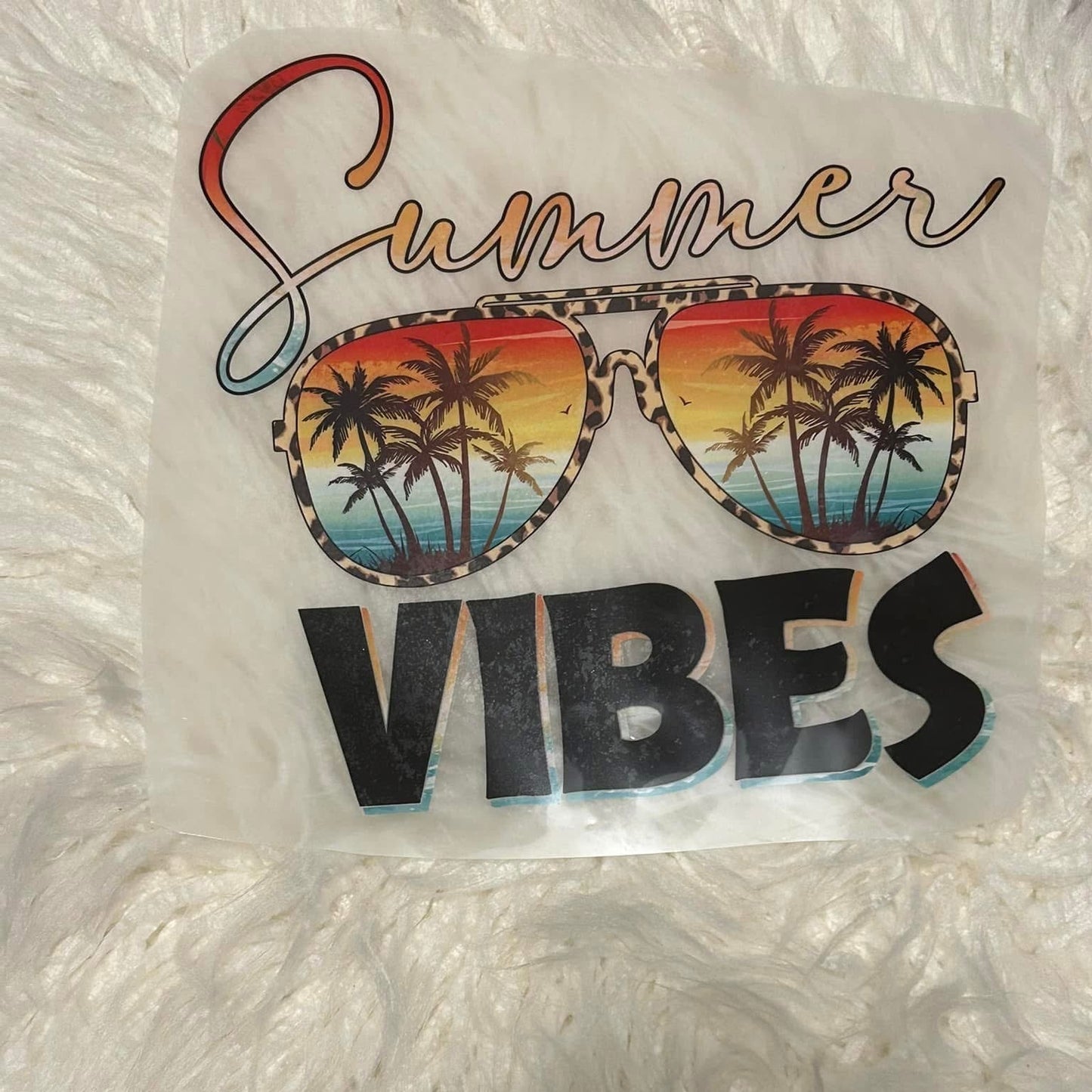 Sticker with 'Summer Vibes' text and sunglasses design on a textured white background