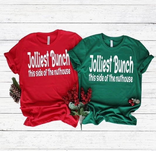 Red and green t-shirts with humorous text on a wooden surface.