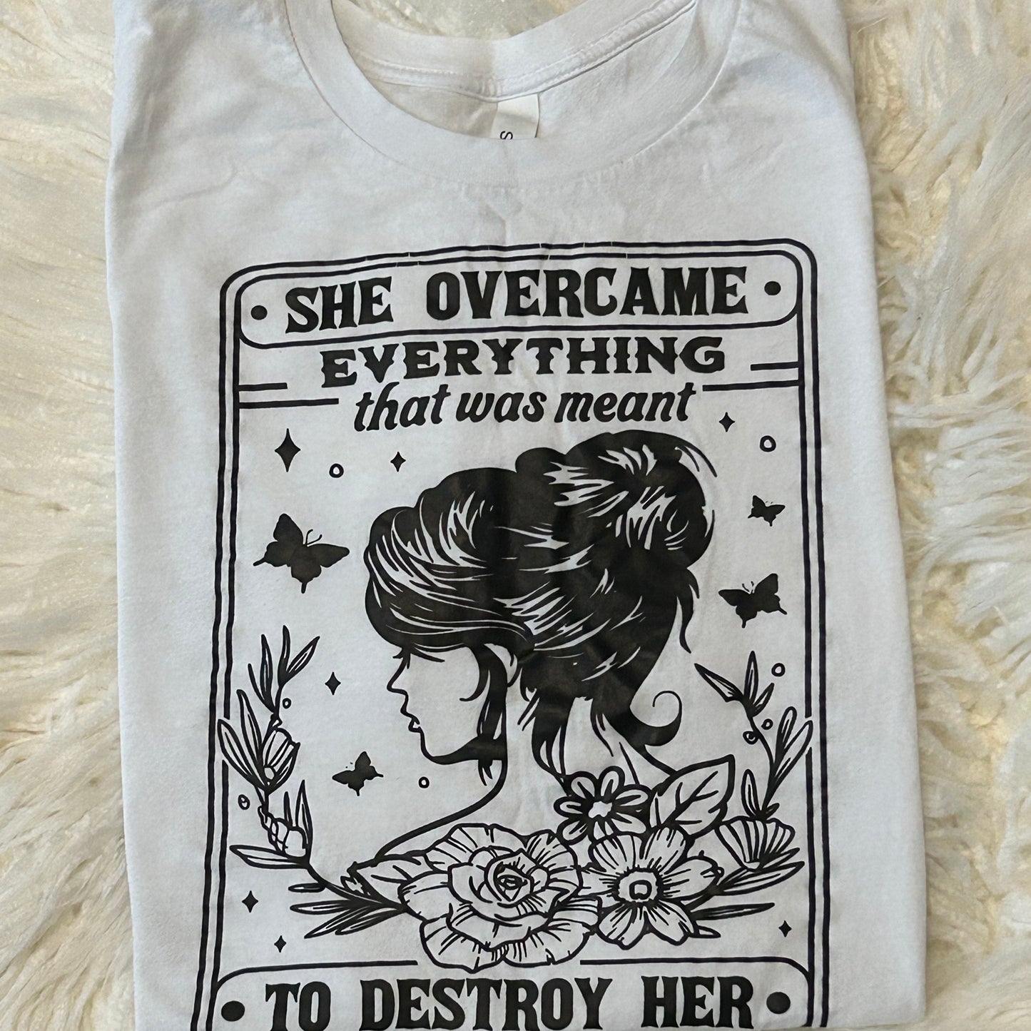 White tank top with black graphic design on a fluffy white surface