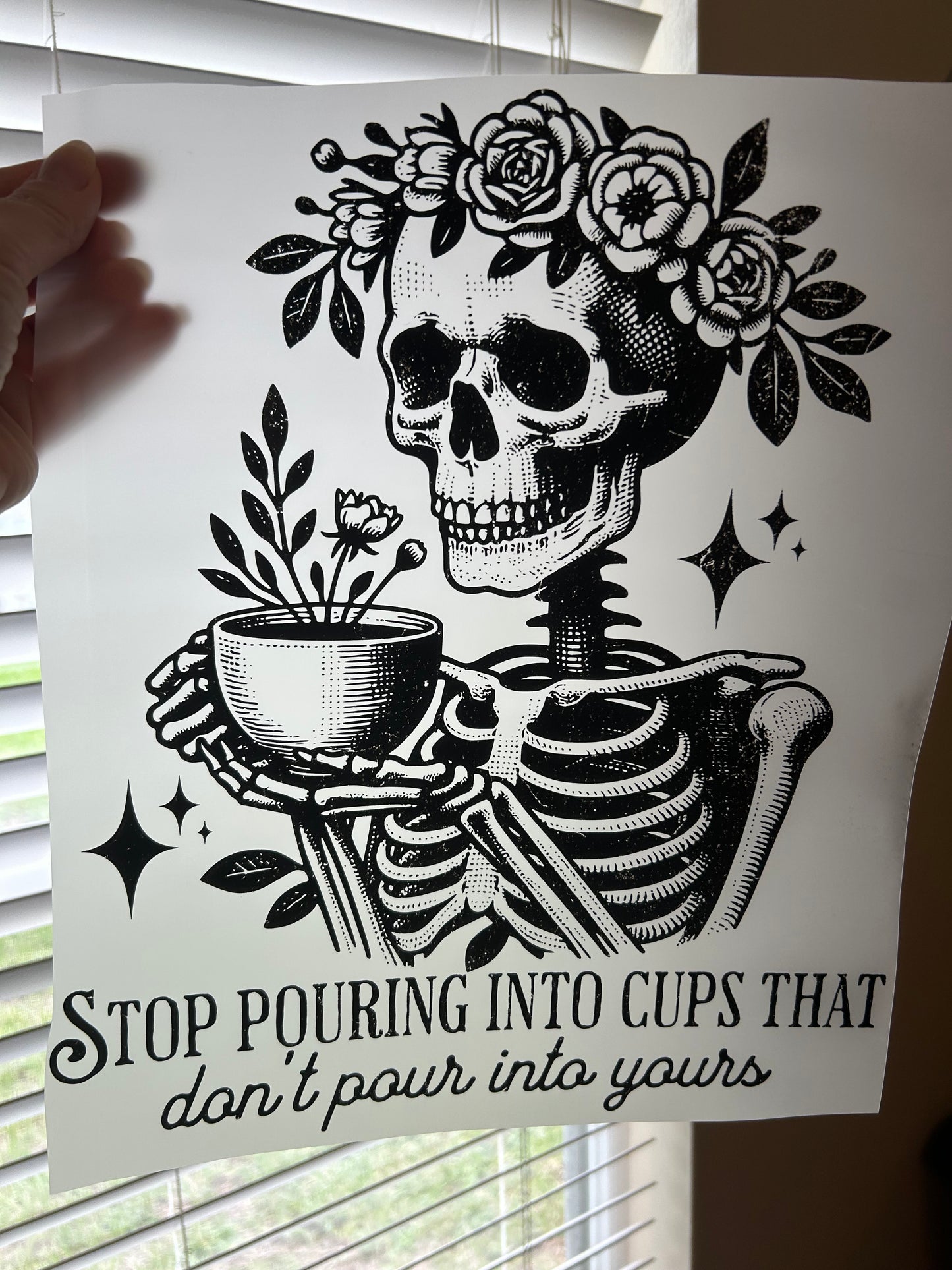 Black and white skull and floral design with text on a white background