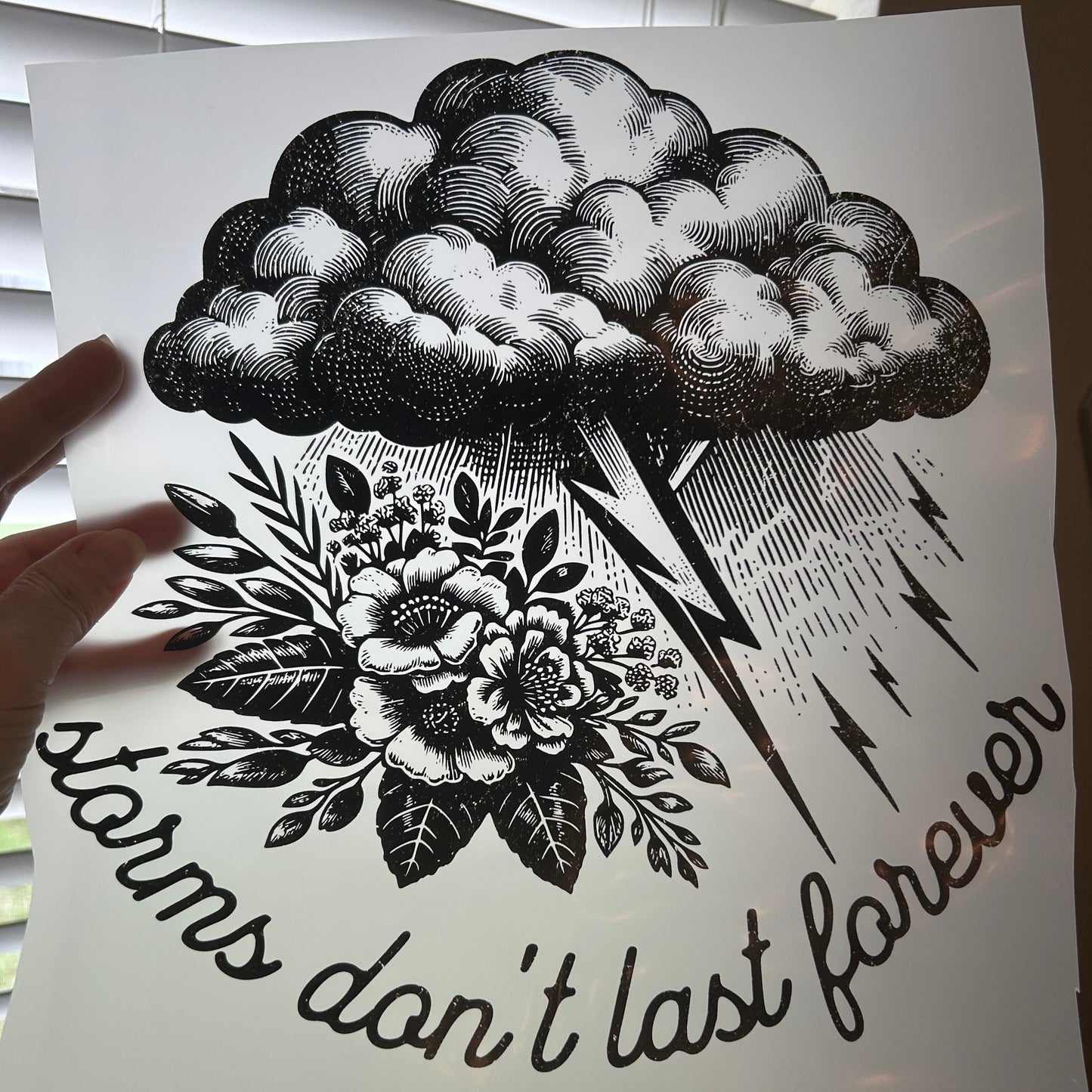 Black and white illustration of a cloud, lightning bolt, and floral design on a white background.