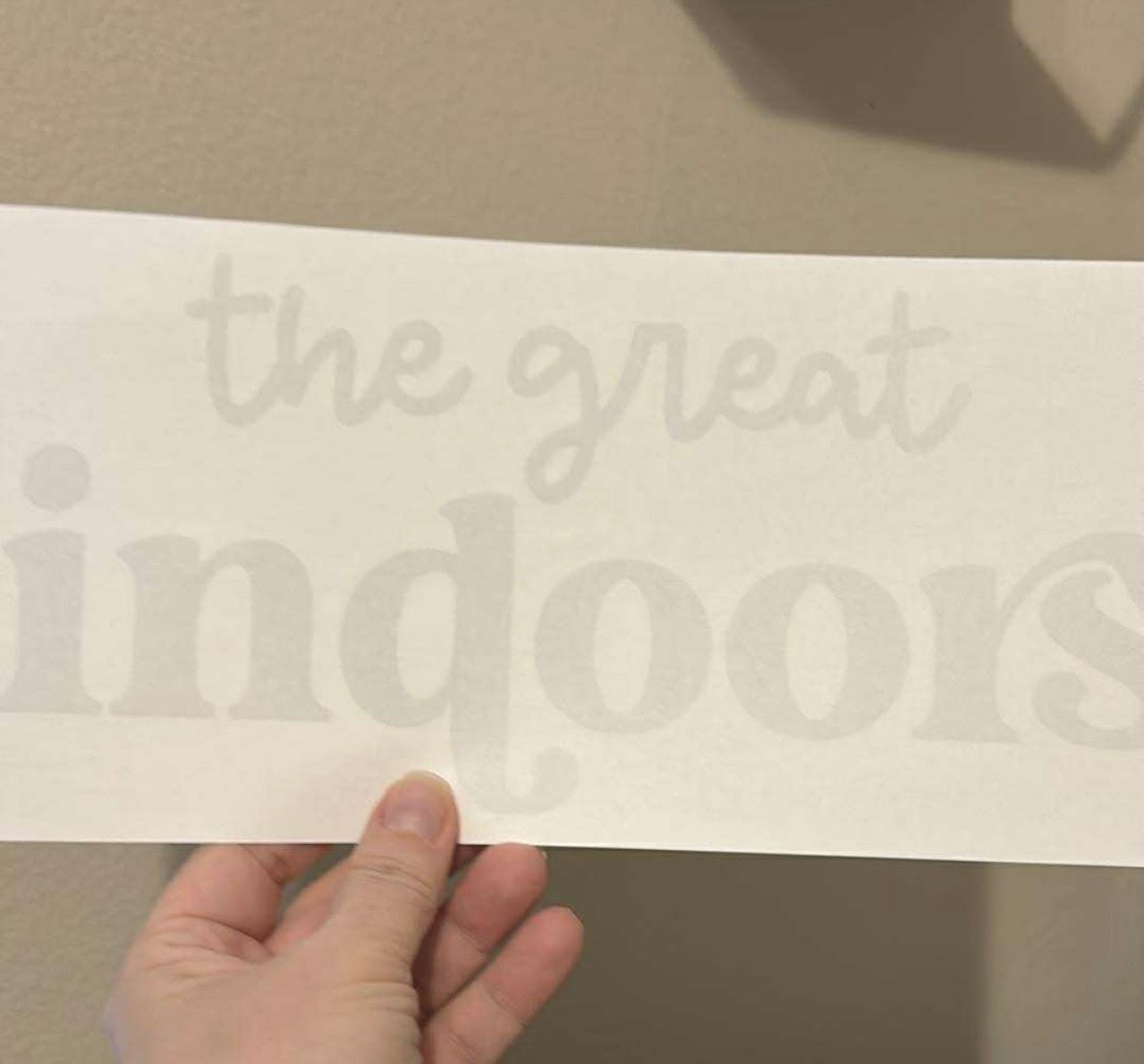 Decal with 'the great indoors' text held against a neutral background
