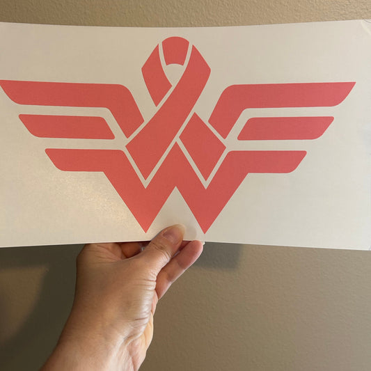 Hand holding a red geometric design against a beige wall