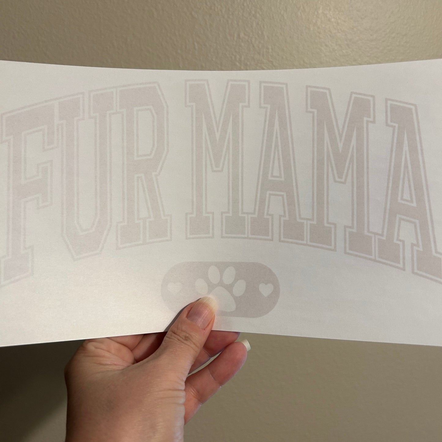 Hand holding a white decal with 'Yamaha' branding against a beige background