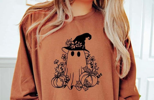 Person wearing a brown sweatshirt with a ghost and pumpkin design, featuring a witch hat.