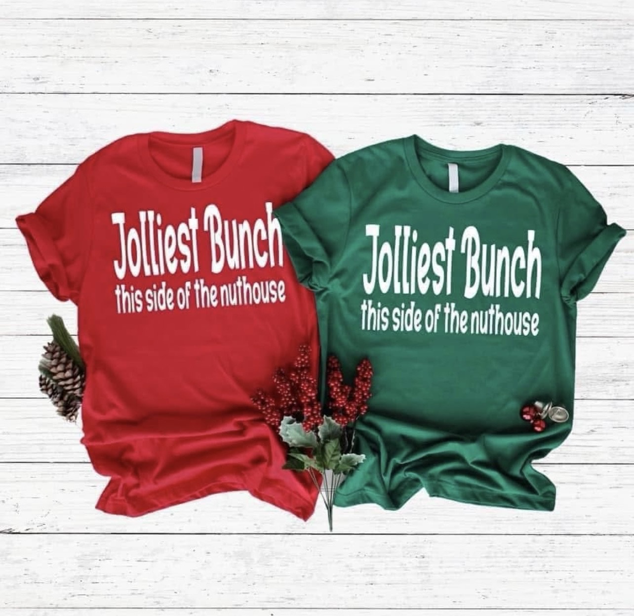 Red and green t-shirts with humorous text on a wooden surface.