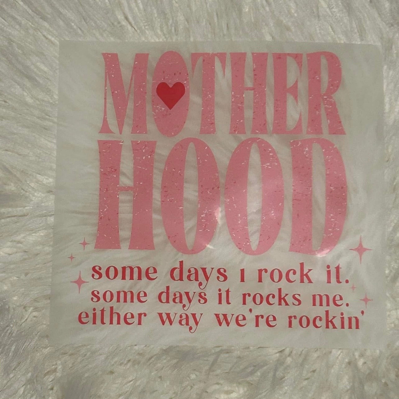 Pink text on a textured gray background with a heart symbol.